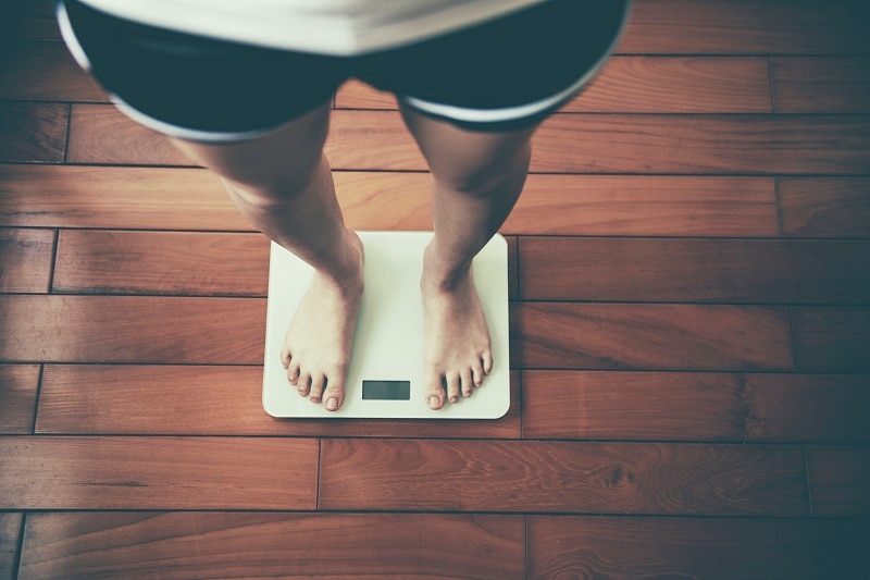 Woman Standing on Scale to Check for Healthy Weight | Vitacost.com/Blog