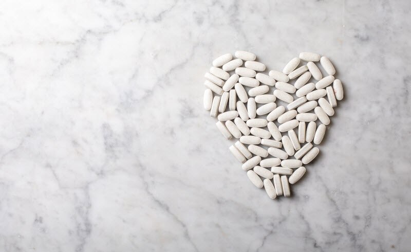 White Calcium Tablets in Heart Shape on White Marbled Surface to Represent Question of Do Dietary Supplements Work | Vitacost.com/blog