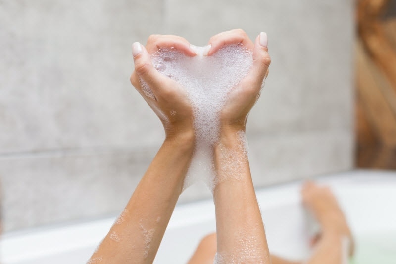 Woman's Hands in Heart Shape Covered in Bubbles to Represent Self Care Practices | Vitacost.com/blog