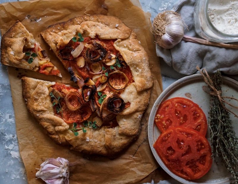 Galette on Baking Paper Next to Garlic and Tomato Slices | Vitacost Blog