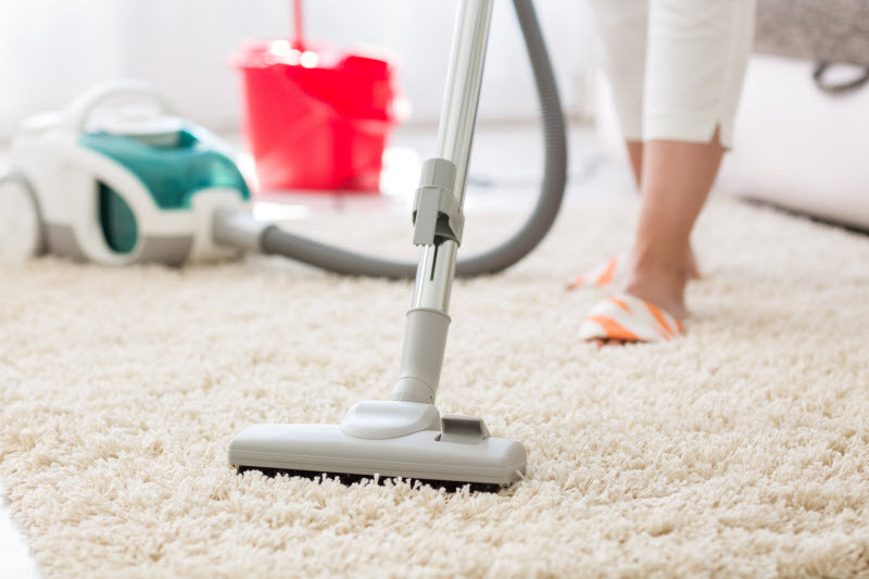 Woman Vacuuming Dirty White Shaggy Rug With DIY Carpet Powder | Vitacost Blog