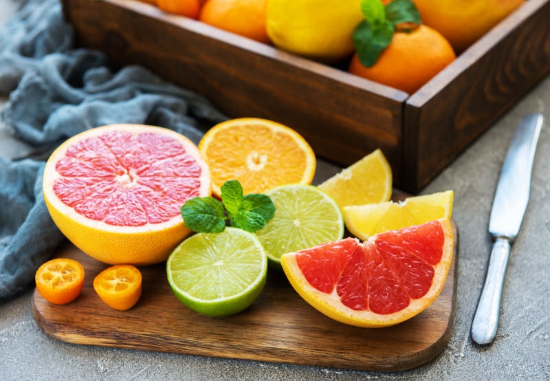 Sliced Grapefruit, Limes, Lemons and Oranges on Wooden Cutting Board to Represent Best Vitamin C Foods | Vitacost.com/blog