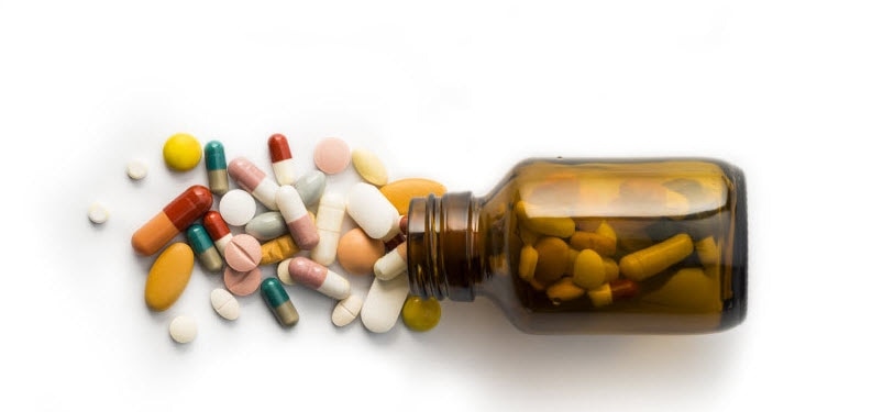 Concept of What Do Dietary Supplements Do Represented by Assortment of Tablets and Capsules Spilling From Amber Bottle | Vitacost.com/blog