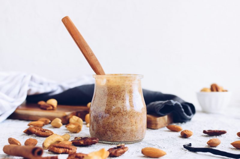 Nut Butter in Clear Jar Surrounded by Loose Nuts | Vitacost Blog