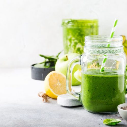 Green Smoothie in Mason Jar in Front of Fruits and Veggies | Vitacost Blog