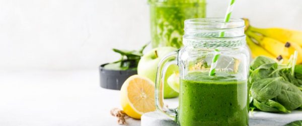 Green Smoothie in Mason Jar in Front of Fruits and Veggies | Vitacost Blog