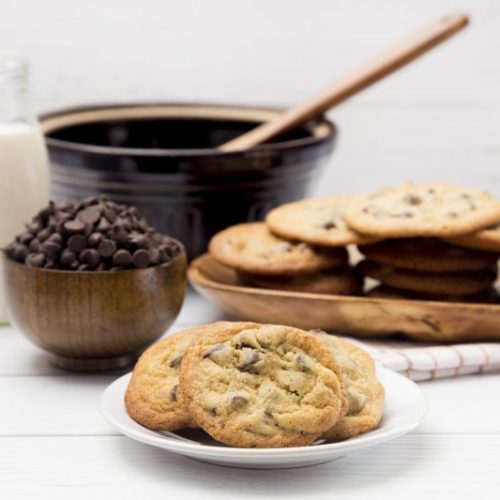 Chocolate Chip Cookies On Small Plate in Front of Stacked Cookies and Milk | Vitacost Blog