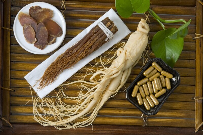Overhead View of Ginseng Root, Capsules and Leaves on Bamboo Surface to Represent Ginseng Benefits | Vitacost.com/blog