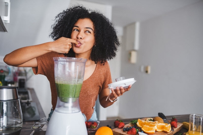Woman Abandoning Diet Trends Tasting Healthy Green Smoothie Right From Her Blender | Vitacost.com/blog
