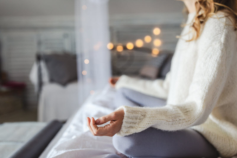 Woman Meditating in Wellness Space Decorated With Peace-Promoting Twinkle Lights | Vitacost.com/blog