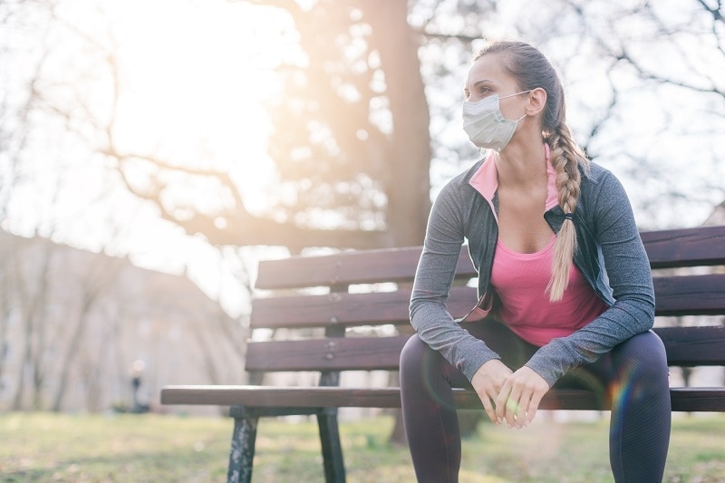 Woman Sitting on Park Bench Wearing Face Mask | Vitacost.com/Blog