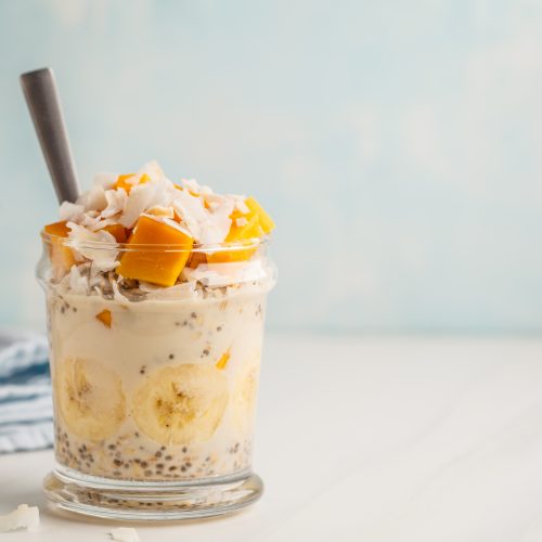 Glass Jar Filled with Oatmeal, Chia seeds, Banana and Topped with Mango and Coconut | Vitacost Blog