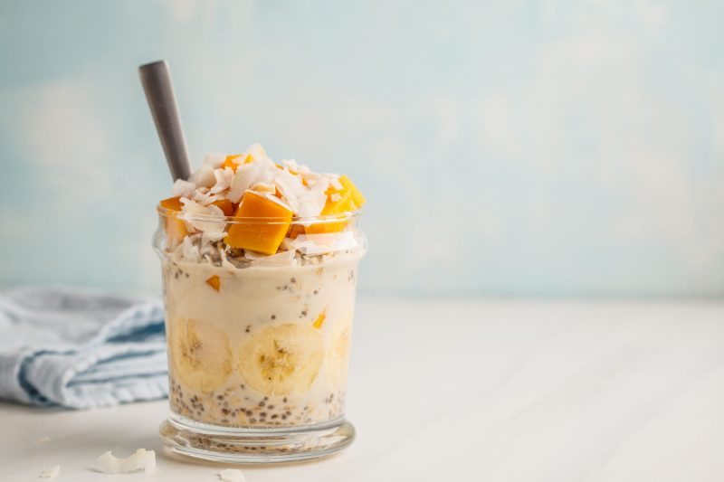Glass Jar Filled with Oatmeal, Chia seeds, Banana and Topped with Mango and Coconut | Vitacost Blog