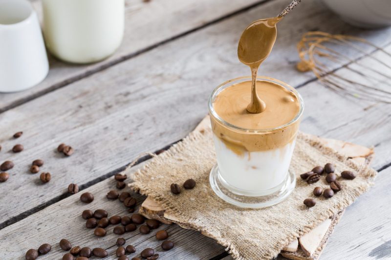 Whipped Coffee Being Poured into Glass on Wood | Vitacost Blog