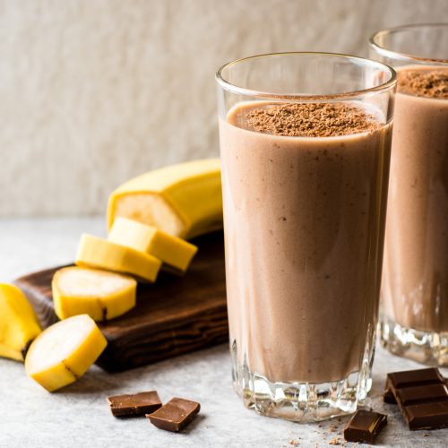 Two Glasses Chocolate Smoothie Next to Sliced Banana | Vitacost Blog