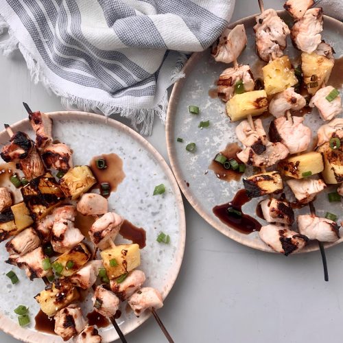 Top View Chicken and Pineapple Kebabs on Plates Drizzled With Brown Sauce | Vitacost Blog