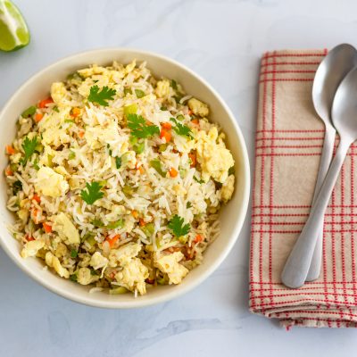 Top View Bowl of Fried Rice Next to Two Spoons on Cloth Napkin | Vitacost Blog