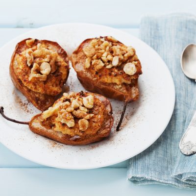 Baked Pears Stuffed with Creamy Filling Topped with Walnuts on White Plate | Vitacost Blog