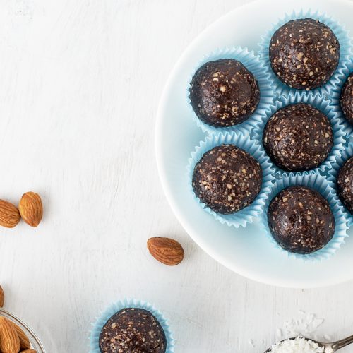 Top View Dark Chocolate Protein Balls on Plate Next to Almonds | Vitacost Blog