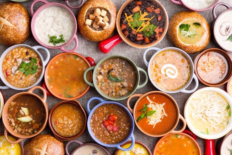 Question of Is Canned Soup Good for You Represented by a Dozen Bowls of Different Soups Together on Table | Vitacost.com/blog