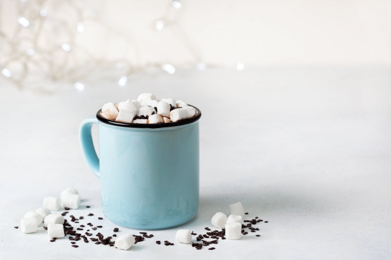 Blue Mug with Cocoa and Marshmallows on White Table to Represent Healthy Winter Drinks | Vitacost.com/blog