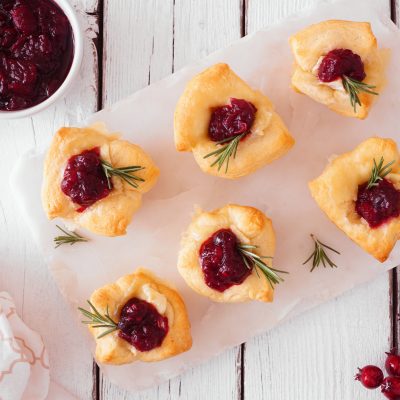 Mini Tarts Filled with Brie and Cranberry Sauce on White Cutting Board | Vitacost Blog