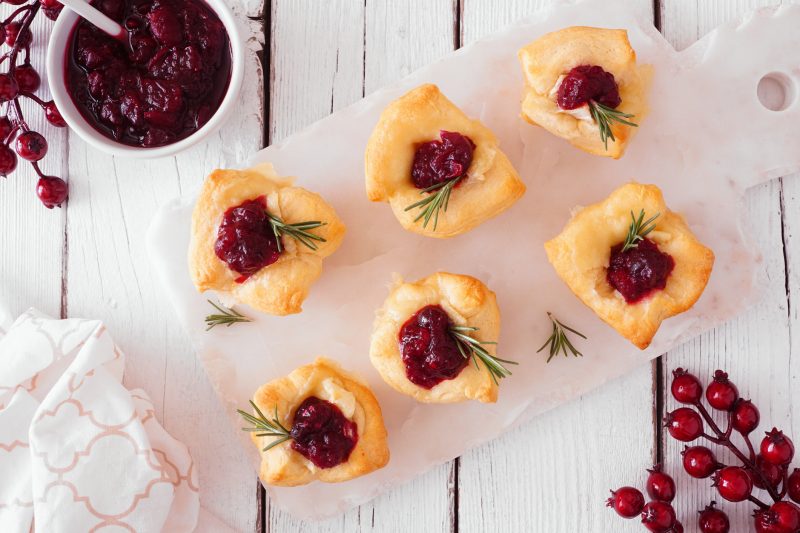 Mini Tarts Filled with Brie and Cranberry Sauce on White Cutting Board | Vitacost Blog