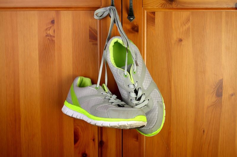 10 Signs You're Out of Shape Athletic Shoes Hanging on Hook on Wooden Wall to Represents Signs You're Out of Shape | Vitacost.com/blog