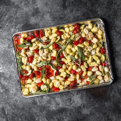 Top View Sheet Pan Full of Gnocchi and Tomatoes Topped with Rosemary | Vitacost Blog