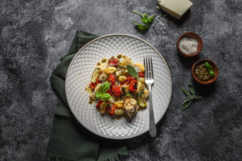 Top View Plate Full of Gnocchi and Tomatoes Next to Cups of Salt and Pepper | Vitacost Blog