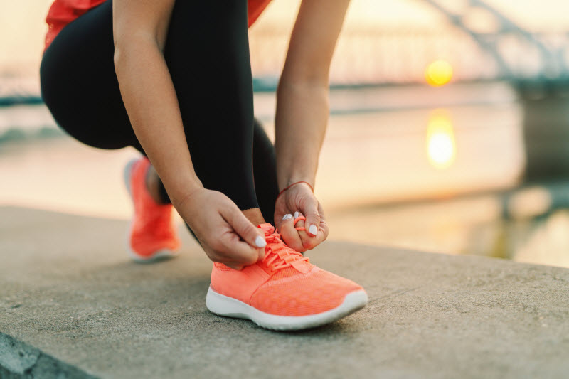 Woman Taking Care of Heart Health Tying Shoe During Exercise Session | Vitacost.com/blog