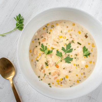 Top View Bowl of Seafood Chowder Garnished with Parsley in White Bowl on White Counter | Vitacost Blog
