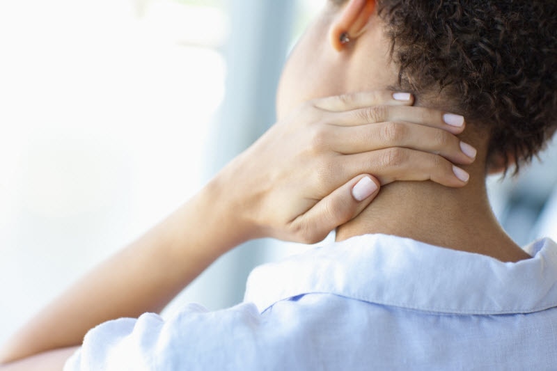 Back View of Woman Performing Health Self Assessment Rubbing Neck to Monitor for Issues | Vitacost.com/blog