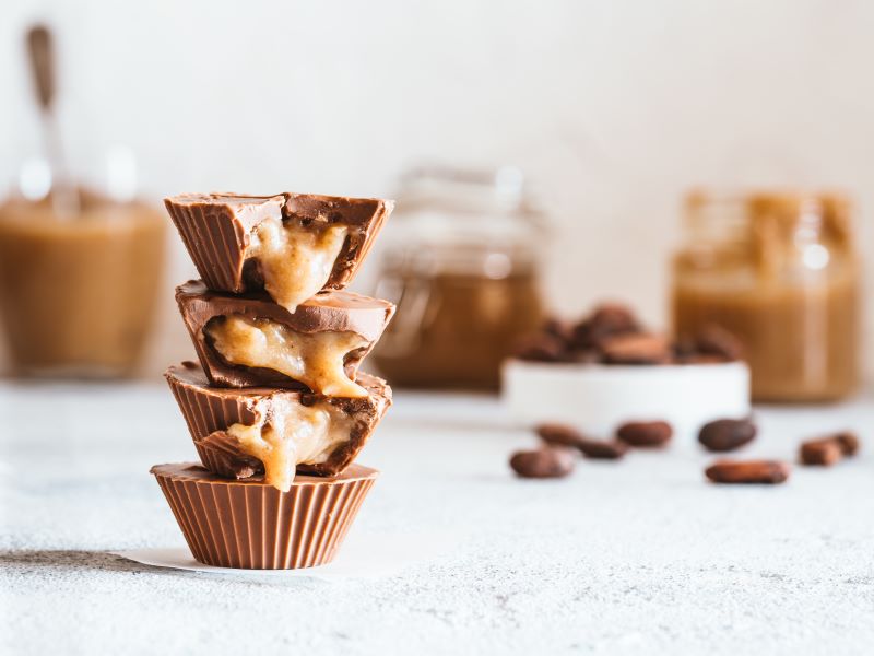 Date-Caramel Chocolate Cups on White Countertop with Ingredients in the Background | Vitacost.com/blog
