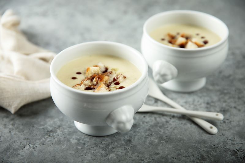 Dairy-Free Irish Potato Soup with Bread Croutons and Balsamic Drizzle in White Bowls on Gray Tabletop | Vitacost.com/blog