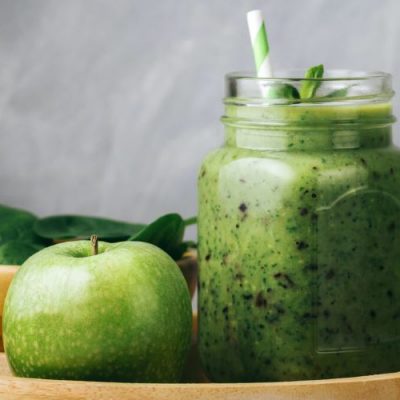 Green Apple Collagen Smoothie in Mason Jar Glass Next to Granny Smith Apple and Spinach in Wooden Bowls | Vitacost.com/blog