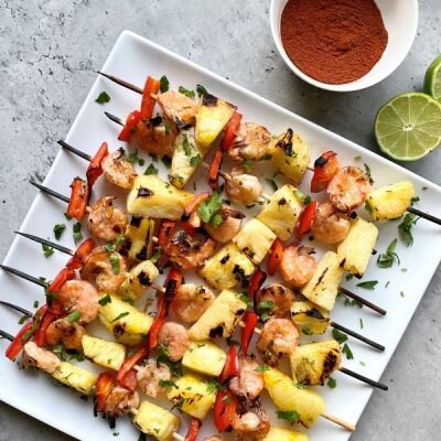 Grilled Shrimp Skewers With Pineapple & Jerk Marinade on White Plate With Limes | Vitacost.com/blog
