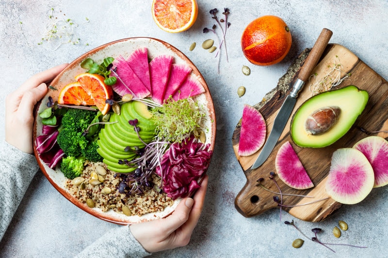 Bowl of Colorful Veggies and Grains on White Marbled Surface to Represent How to Add Variety to Your Diet | Vitacost.com/blog