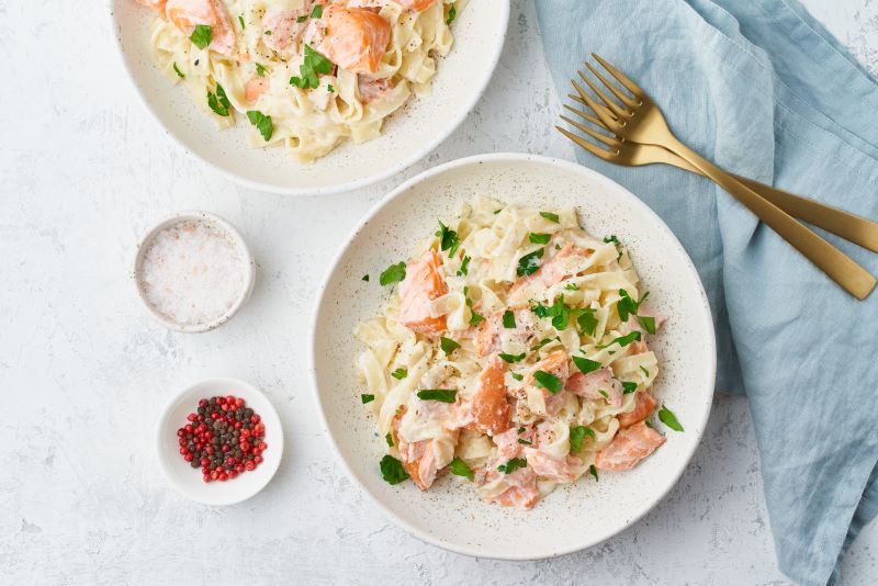 Dairy-Free Creamy Salmon Pasta on White Plate with Blue Napkin | Vitacost.com/blog