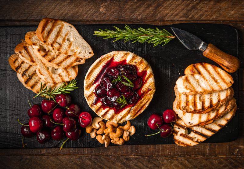 Grilled Brie Recipe with Cherry Sauce on Cheese Board with Grilled Bread and Rosemary Sprigs | Vitacost.com/blog