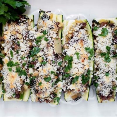 Stuffed Zucchini Boats With Beef, Veggies & Cheese on White Serving Plate | Vitacost.com/Blog