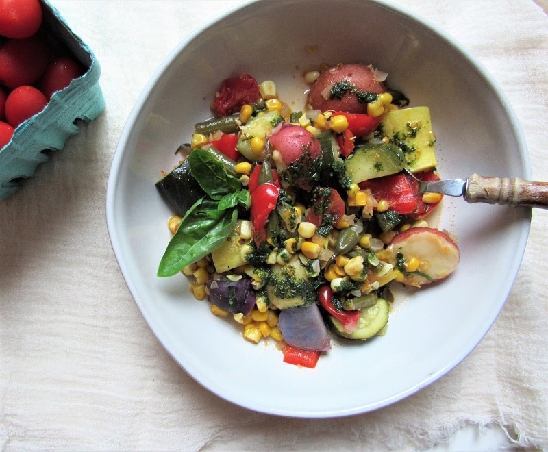Bowl of Vegetable Stew with Colored Potatoes, Corn, Cherry Tomatoes, Herb Puree and More to Represent Vegetable Stew Recipe | Vitacost.com/Blog