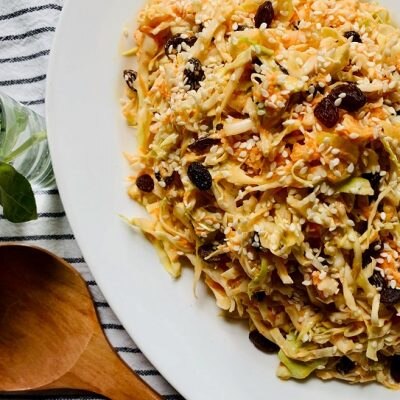 Homemade Dairy-Free Summer Cabbage Slaw on White Platter Next to Wooden Serving Spoon | Vitacost.com/Blog