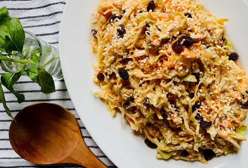 Homemade Dairy-Free Summer Cabbage Slaw on White Platter Next to Wooden Serving Spoon | Vitacost.com/Blog