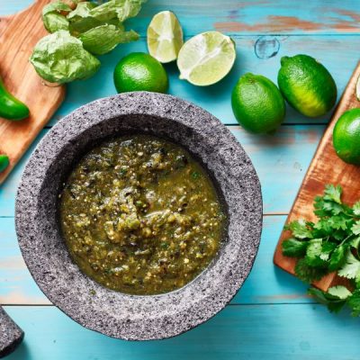 Tomatillo Salsa Verde in Stone Bowl on Countertop with Limes, Jalapenos & Cilantro | Vitacost.com/blog