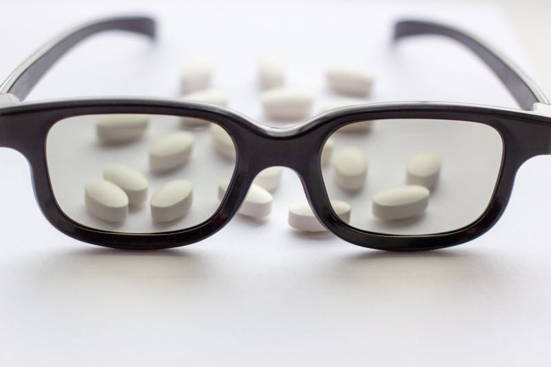 What is Lutein Represented by Black Glasses and Supplement Capsules on White Surface | Vitacost.com/blog