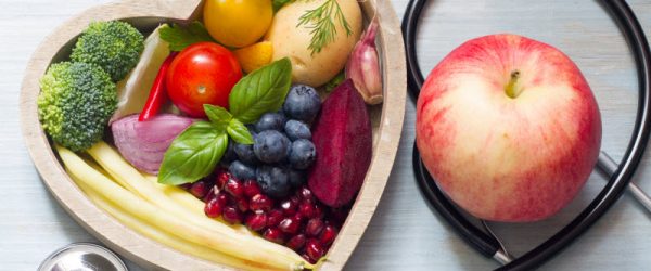 Fruits & Vegetables in Wooden Heart Bowl With Stethoscope to Represent Concept Can You Reverse High Cholesterol with Plant Foods | Vitacost.com/blog