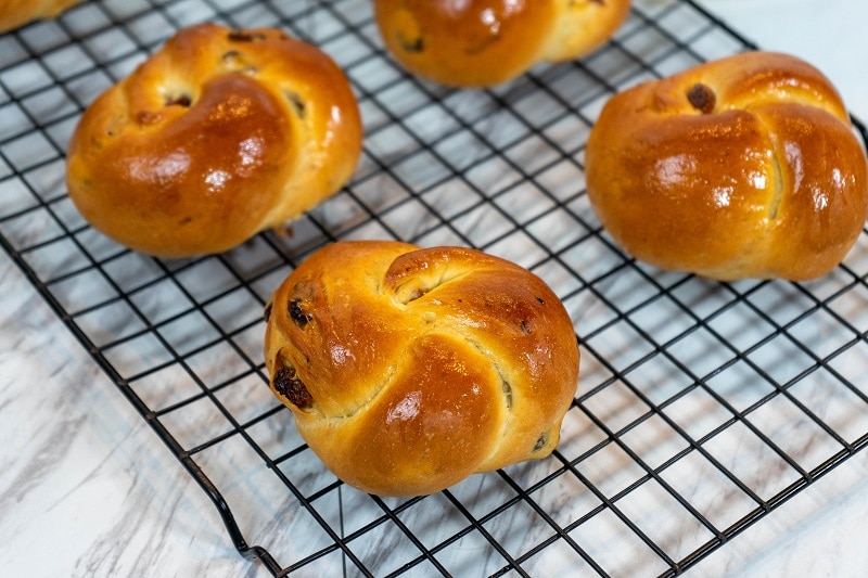 Round, Braided Challah Bread Loaves With Raisins Sit on a Cooling Rack to Represent Vegan Challah | Vitacost.com/Blog