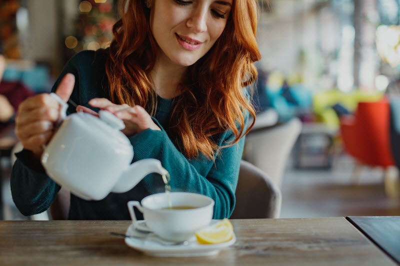 Woman Pouring Tea into Mug to Represent Stress Relievers Concept | Vitacost.com/blog
