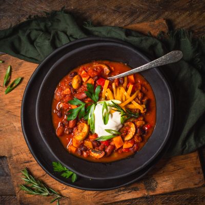 Homemade Meatless Mushroom-Bean Chili Topped with Sour Cream, Cheese & Herbs in Bowl | Vitacost.com/Blog